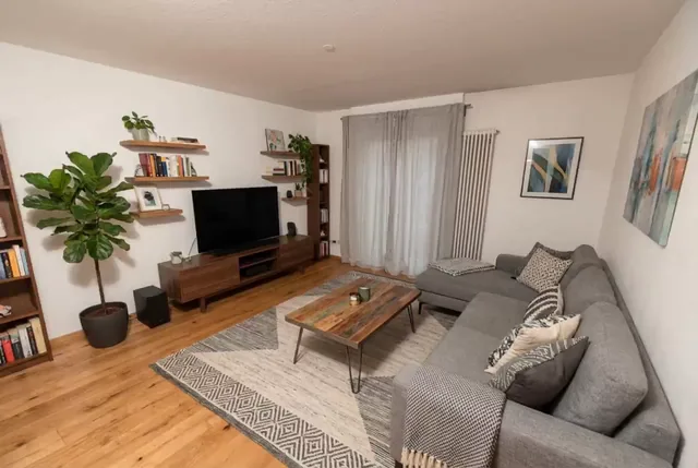 Standbild aus einem KI-Objektvideo: Wohnzimmer mit Sofa und Regalen