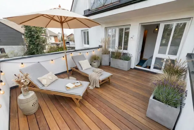 Standbild aus einem KI-Objektvideo: Dachterrasse mit Liegen und Sonnenschirm